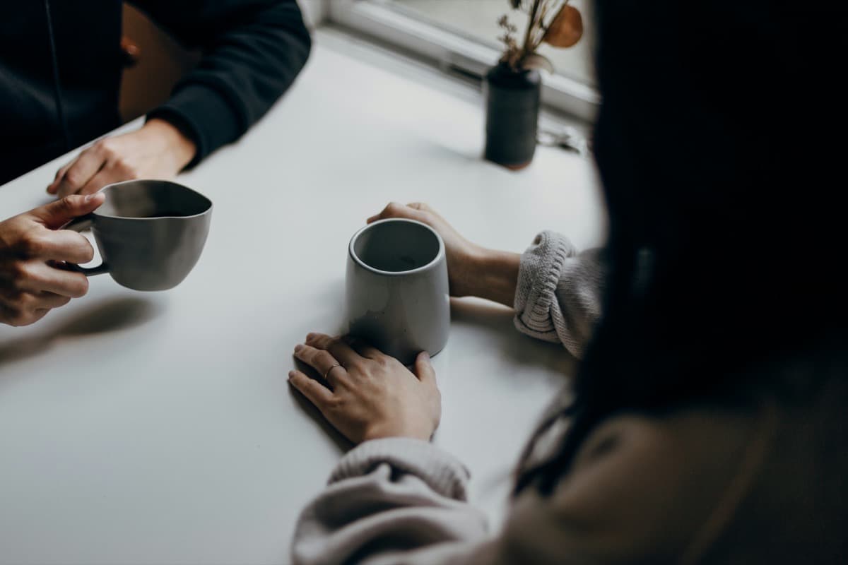 Two people sharing a genuine conversation over coffee